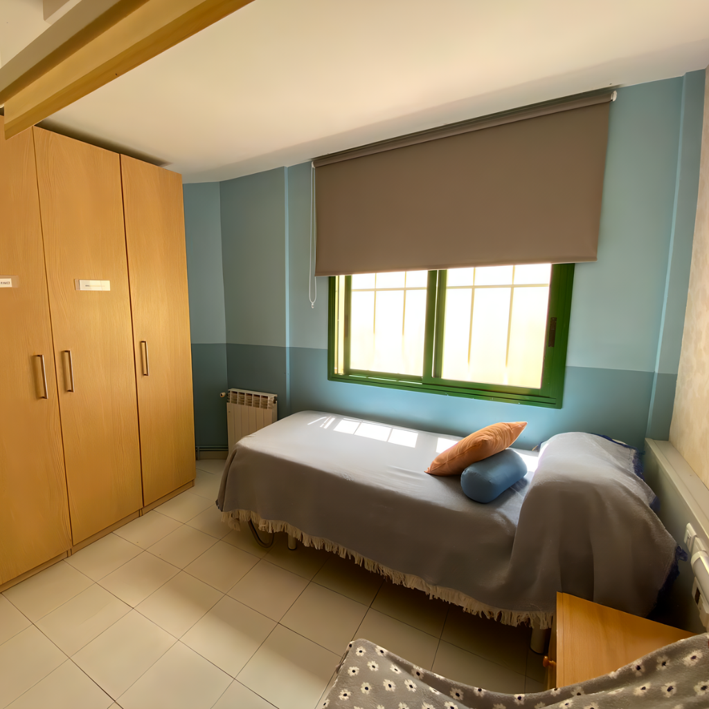 Habitación luminosa de la residencia con dos camas bien hechas y cojines decorativos