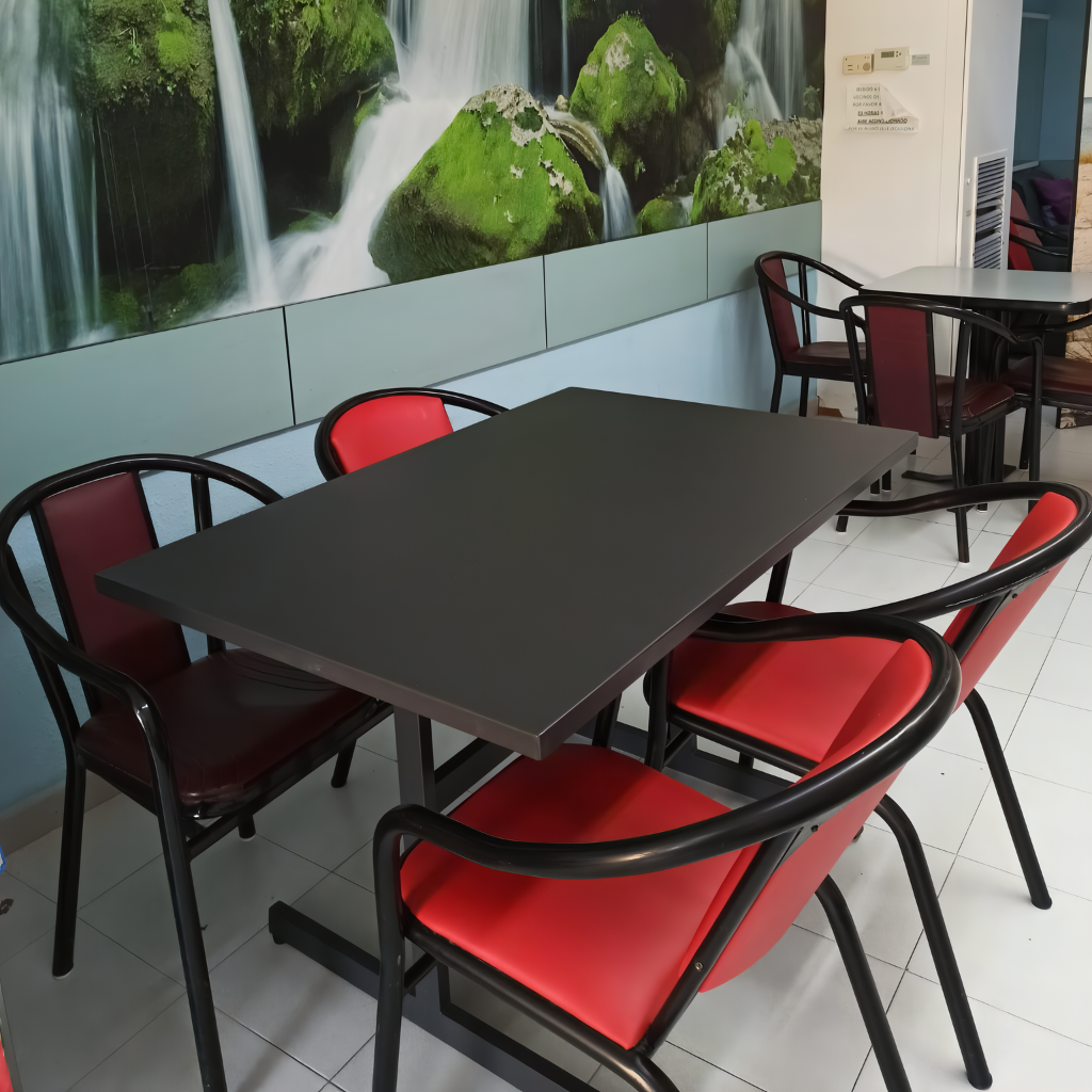 El comedor de nuestra residencia, con mesas y sillas dispuestas y un atractivo vinilo verde en la pared y un separador de ambientes